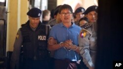 Reuters journalist Wa Lone is escorted by police as he leaves court outside Yangon, Myanmar, Jan. 10, 2018.