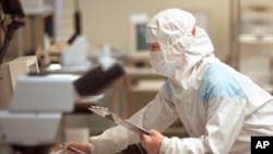 芯片技術人員在台灣聯華電子公司（UMC）的“潔淨室”測試設施檢查硅片(資料照片)