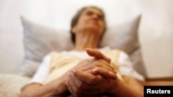 FILE - Alzheimer's disease patient Isidora Tomaz, 82, sits in an armchair in her house in Lisbon, Portugal.