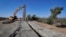 Government contractors erect a section of border wall along the Colorado River, Sept. 10, 2019 in Yuma, Ariz. Construction began as federal officials revealed a list of Defense Department projects to be cut to pay for the wall.
