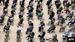 مردم در انتظار دریافت واکسن در سالنی در تهران (آرشیو)