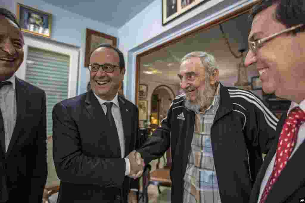 Cuba's former leader Fidel Castro shakes hands with French President Francois Hollande, while accompanied by Cuba's Foreign Minister Bruno Rodriguez (right) in Havana, Cuba, May 11, 2015.