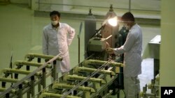 伊朗技術人員在生產鈾燃料的設施前工作。（2009年4月9日）