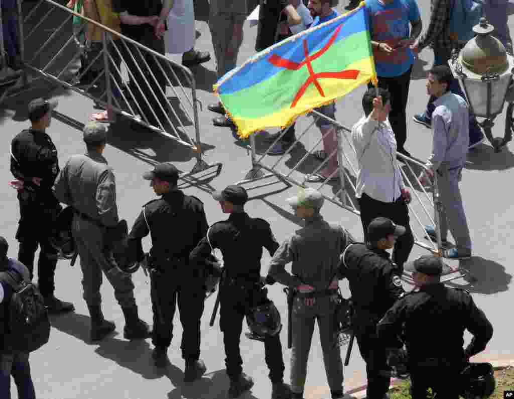 Wani na dauke da tutar Abzinawa a gaban wasu 'yansanda a lokacin wata zanga zanga ta nuna rashin amincewarsu da gwamnatin akan saboda yawan cin hanci da rashawa, ranar Lahadi 11 ga watan Yuni shekarar 2017. &nbsp;