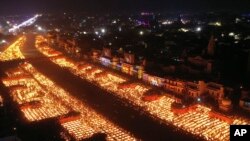 People light lamps on the banks of the river Saryu in Ayodhya, India, Wednesday, Nov. 3, 2021. Millions of people across Asia are celebrating the Hindu festival of Diwali, which symbolizes new beginnings and the triumph of good over evil and light over da