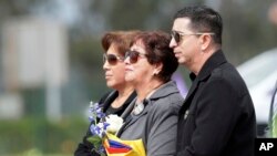 ARCHIVO - Ricardo Rivas acompaña a su madre Guadalupe Bravo, centro, para recibir los restos de su hijo, su hermano, el fotoperiodista de El Comercio Paul Rivas, en Quito, Ecuador, el 27 de junio de 2018.