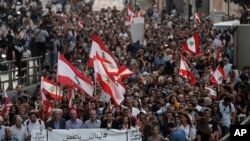 Anti-government protesters march during a protest against the central bank and the Lebanese government, in Beirut, Lebanon, Thursday, Oct. 31, 2019.