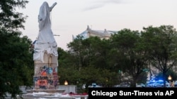 រូបឯកសារ៖ ប៉ូលិស​ដើរ​ជុំវិញ​កន្លែង​នៃ​រូបសំណាក​លោក Christopher Columbus បន្ទាប់ពី​ក្រុមអ្នកតវ៉ា បាន​ប៉ុនប៉ង​ផ្តួលរំលំ​រូបសំណាក​ដែល​មាន​ទីតាំង​នៅក្នុង​ទីក្រុង ទីក្រុង​ឈីកាហ្គោ នៅ​ថ្ងៃទី១៧ ខែកក្កដា ឆ្នាំ២០២០។