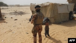 Mwanajeshi apita karibu na mtoto wakati anapiga doria nchini Mali. March 25, 2019.