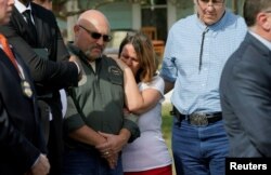 Pastor Frank Pomeroy, with his wife Sherri, listens at a news conference outside the site of the shooting at his church, the First Baptist Church of Sutherland, Texas, Nov. 6, 2017.