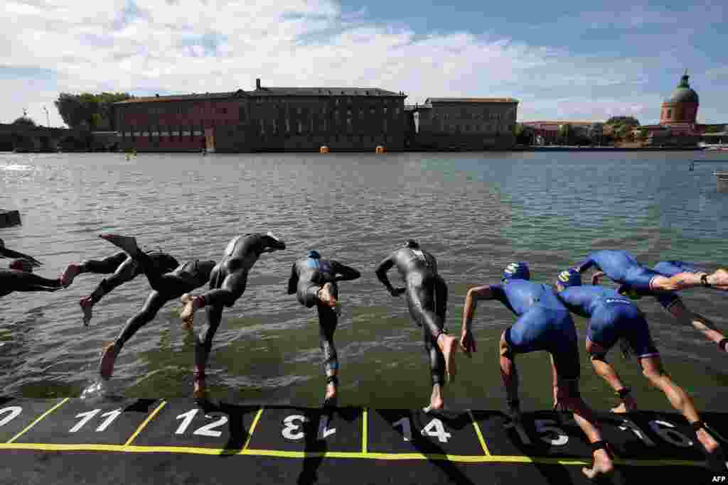 Triathletes dive into the Garonne river as they compete in the men's Supertri triathlon in Toulouse, south-western France.