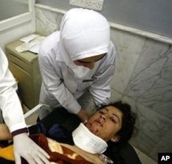 FILE - A wounded Iraqi woman receives medical care at a hospital in the northern Iraqi city of Mosul, after a double bomb attack targeting buses carrying Christian students and university workers near Mosul in killed a shopkeeper and wounded 80 other people in April 2012. 02