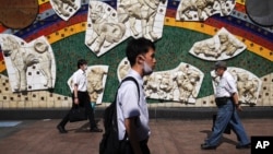 People wearing a protective face mask to help curb the spread of the coronavirus walk in Tokyo Thursday, July 2, 2020. Japan lifted a seven-week pandemic state emergency in late May, and social and business activity have since largely resumed. (AP…