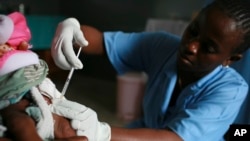 FILE- A child is vaccinated during a malaria vaccine trial in Bagamoyo, Tanzania in Aug. 2007. 