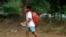 A Cambodian school girl runs home after her morning primary school in Rokar Tnong village on the outskirts of Phnom Penh, Cambodia, Thursday, Oct. 6, 2011. (AP Photo/Heng Sinith)