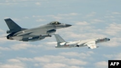 台湾F16战机监控伴飞在台湾南部巴士海峡上空飞行的中国空军H-6K轰炸机。(2018年5月11日)