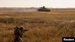 A serviceman of the Ukrainian Armed Forces takes part in military drills at a training ground near the border with Russian-annexed Crimea in Kherson region, Ukraine, in this handout picture released by the General Staff of the Armed Forces of Ukraine press service, Nov. 17, 2021.