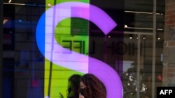 Una mujer usando máscara de protección habla por teléfono frente a una tienda en Ciudad México, México, el 1 de diciembre de 2020.