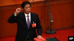 新当选的中国人大委员长栗战书2018年3月17日在全国人大全体会议上手按宪法，宣誓就职。