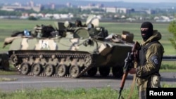 A Ukrainian soldier, supported by armoured personnel carriers, mans a checkpoint near the town of Slaviansk in eastern Ukraine May 3, 2014