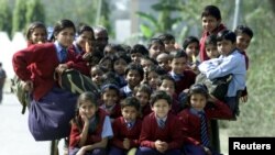 Indian children ride in a cart on the way home from school in the outskirts of New Delhi in this file picture taken, February 26, 2001. REUTERS/Pawel Kopcznski/Files 