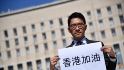 Hong Kong exiled pro-democracy activist Nathan Law holds a placard outside the Italian Foreign Ministry headquarter as he speaks to media, during the meeting between Italian Foreign Minister and his Chinese counterpart in Rome on August 25, 2020