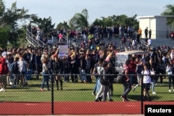 FILE - Students walk out at Marjory Stoneman Douglas High School during National School Walkout to protest gun violence in Parkland, Florida, March 14, 2018.