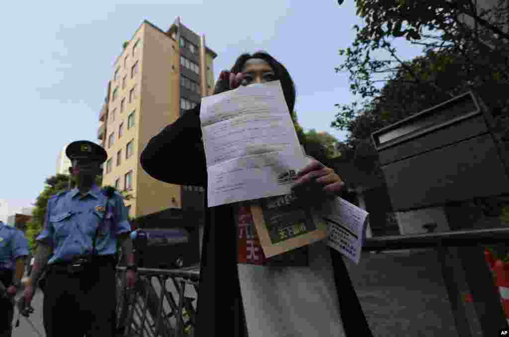 A demonstrator shows a letter of protest before dropping it into the mailbox of the Chinese Embassy in Tokyo, June 4, 2014.
