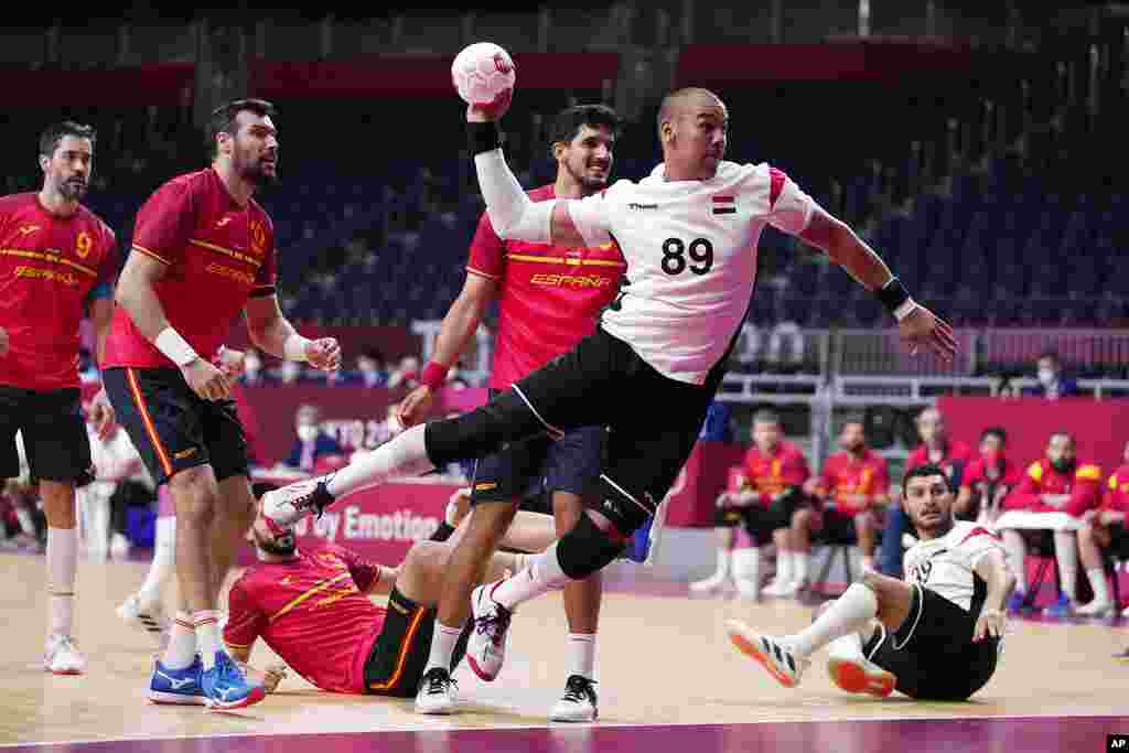 Mohamed Shebib, do Egipto, centro, marca durante o jogo de andebol com a Espanha na disputa pela medalha de bronze. 7 de Agosto, 2021. Tóquio, Japão. (AP Photo/Pavel Golovkin)