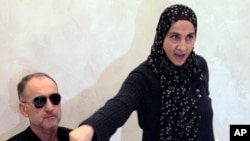 Zubeidat Tsarnaeva, mẹ của hai nghi phạm vụ đánh bom Boston, phát biểu tại một cuộc họp báo trong lúc người cha Anzor Tsarnaev lắng nghe.