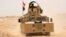 Iraqi government forces drive their armored vehicle, June 22, 2016, some 40 kilometers (25 miles) west of Qayyarah, during their operation to take the city and make it a launchpad for Mosul. 