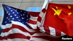 Bendera nasional AS dan China berkibar di depan sebuah hotel internasional di Beijing, 4 Februari 2010. (Foto: Reuters)