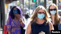People wearing face protective masks walk on Hollywood Blvd during the outbreak of the coronavirus disease (COVID-19), in Los Angeles, California, U.S., March 29, 2021. 