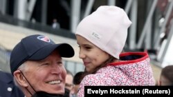 Rais wa Marekani Joe Biden akimsalimia mtoto katika kundi la wakimbizi wa Ukrainian huko kwenye Uwanja wa Taifa wa PGE Warsaw, Poland Machi 26, 2022. REUTERS/Evelyn Hockstein