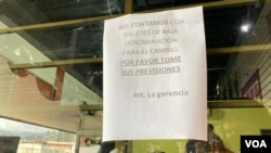 Un cartel en un local de Caracas informa a los clientes que no cuentan con billetes de baja denominación para dar el cambio, Venezuela. Foto: Adriana Nuñez Rabascall - VOA.