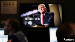 Televisi menayangkan pemberitaan mengenai mantan presiden AS Donald Trump yang didakwa menyuap bintang porno Stormy Daniels, di NYSE New York City , AS, 31 Maret 2023. (Foto: REUTERS/Andrew Kelly)