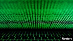 FILE- A computer keyboard lit by a displayed cyber code is seen in this illustration.