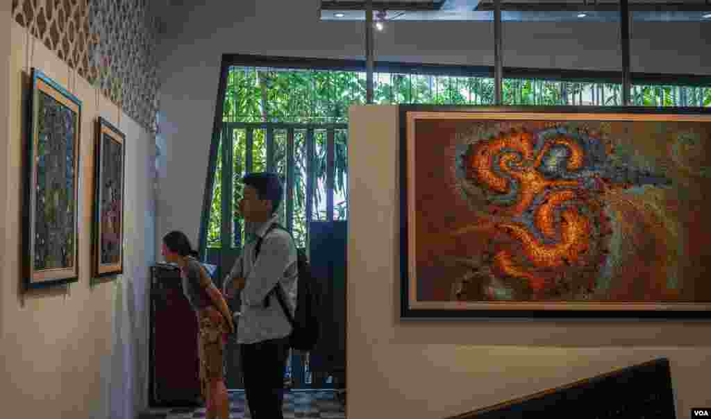 សាធារណជន​សញ្ជឹង​មើល​​ផ្ទាំង​គំនូររបស់​ វិចិត្រករ សាង ណាន់ ដែលបង្ហាញនូវភាពឈឺចាប់​ និង​ក្តីសង្ឃឹមរបស់​ប្រជាជនខ្មែរ​ដែលបានរស់ក្នុងសម័យខ្មែរក្រហម​ និង​តស៊ូក្នុងជីវិតបច្ចុប្បន្ន​។​ គំនូរទាំង១១ ផ្ទាំងរបស់លោក​ត្រូវបាន​តាំង​បង្ហាញ​​នៅកម្មវិធីមហោស្រពភាពយន្តអន្តរជាតិកម្ពុជាលើកទី៩, នៅរាជធានីភ្នំពេញ, នៅថ្ងៃទី១២ ខែមីនា​ ឆ្នាំ២០១៩។ (ខាន់ សុគុំមនោ/VOA)