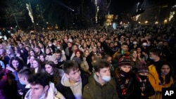 Watu wakishehekea wakati wa Mkesha wa Mwaka Mpya, huko Belgrade, Serbia. Sherehe za Mkesha wa Mwaka mpya zilifanyika Serbia Belgrade tofauti na kwingineko barani Ulaya, ambako mikusanyiko ya watu wengi iliruhusiwa licha ya ongezeko la maambukizi ya corona, aina ya Omicron.