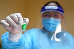 រូបឯកសារ៖ បុគ្គលិកសុខាភិបាលម្នាក់បង្ហាញវ៉ាក់សាំងបង្ការជំងឺកូវីដ១៩ Covishield នៅមន្ទីរពេទ្យមួយកន្លែងក្នុងរាជធានីភ្នំពេញ កាលពីថ្ងៃទី ២២ ខែមីនា ឆ្នាំ ២០២១។