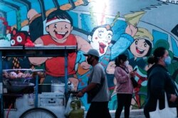 Orang-orang yang memakai masker berjalan pada jam-jam sibuk saat pemerintah memperpanjang pembatasan untuk menekan penyebaran COVID-19 di Jakarta, 21 September 2021. (Foto: REUTERS/Ajeng Dinar Ulfiana)