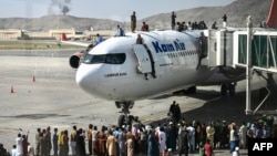 ប្រជាជន​អាហ្វហ្គានីស្ថាន​ហក់​ឡើង​លើ​យន្ដហោះ​មួយ​គ្រឿង នៅ​អាកាសយានដ្ឋាន​អន្តរជាតិ​ក្នុង​រដ្ឋធានី​កាប៊ុល ប្រទេស​អាហ្វហ្គានីស្ថាន ថ្ងៃទី១៦ ខែសីហា ឆ្នាំ២០២១។ 