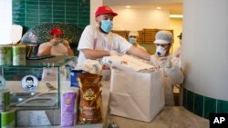 Pizzas are being prepared for home delivery at the Caputo pizzeria in Naples, Monday, April 27, 2020. Region Campania allowed cafes and pizzerias to reopen for delivery Monday, after a long precautionary closure due to the coronavirus outbreak. (AP Photo/Andrew Medichini)