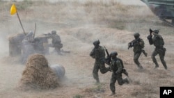 FILE - Soldiers rush after alighting from an assault amphibious vehicle during a military drill in Kaohsiung City, Taiwan, Jan. 12, 2023. Taiwan's annual war games this year will be as close as possible to actual combat.
