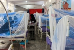 Women wait with children in a ward at a malnourishment treatment center in Yemen's northern Hajjah province, Nov. 22, 2020.