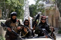 Kelompok Taliban mengibarkan bendera mereka saat berpatroli di Kabul, Afghanistan, 19 Agustus 2021. (Foto: AP)