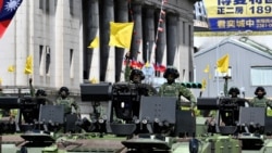 Taiwanese soldiers raise flags on military vehicles during a national day parade in front of the Presidential Palace in Taipei, Oct. 10, 2021.