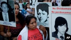 La gente lleva fotos de las víctimas de la dictadura de 1976-83, durante una marcha que conmemora el 41 aniversario del golpe militar en Buenos Aires, Argentina, el viernes 24 de marzo de 2017.