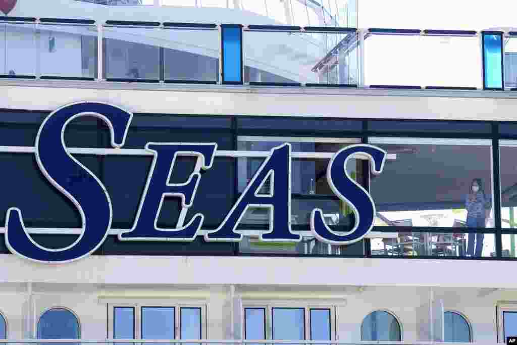 A passenger looks out from the Spectrum of the Seas cruise ship docked at Kai Tak cruise terminal in Hong Kong. Thousands of passengers were being held on a cruise ship in Hong Kong for coronavirus testing.