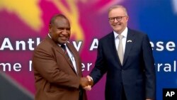 Perdana Menteri Australia Anthony Albanese (kiri) berjabat tangan dengan Perdana Menteri Papua Nugini James Marape di luar parlemen di Port Moresby, Papua Nugini, Kamis, 12 Januari 2023. (Pool Australia via AP)